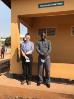 Two men stand outside of Gulu Hospital